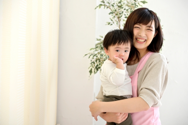 子どもを抱っこする　笑顔の保育士