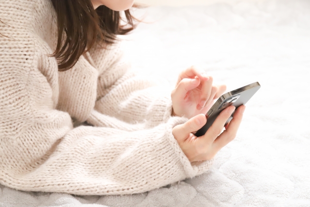 スマホをもって観る女性　柔らかい雰囲気