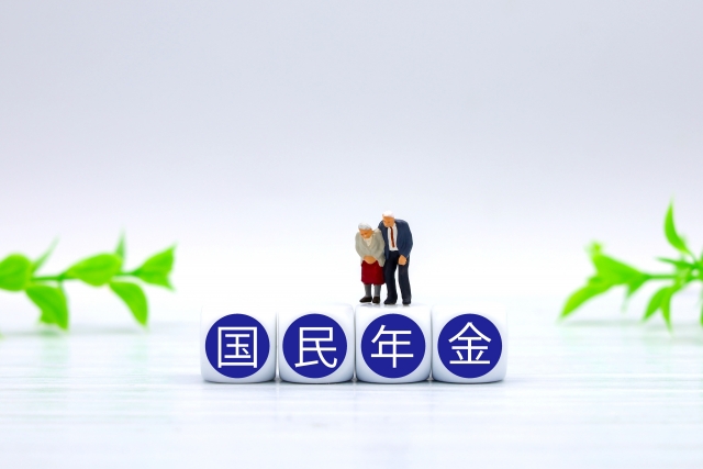 国民年金の文字積み木と、疲れた老夫婦